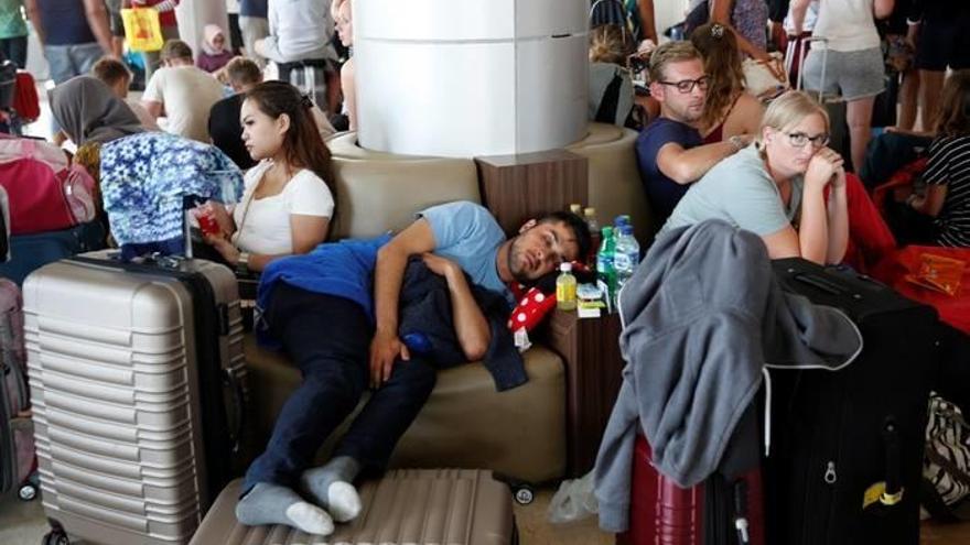 Turistas extranjeros esperan su vuelo en el aeropuerto Internacional Praya en Lombok (Indonesia) hoy.