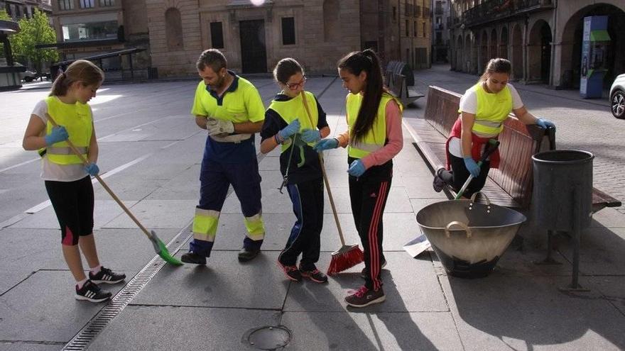 Un grupo de alumnas de Santa Ana, limpiando en la plaza de los Fueros.