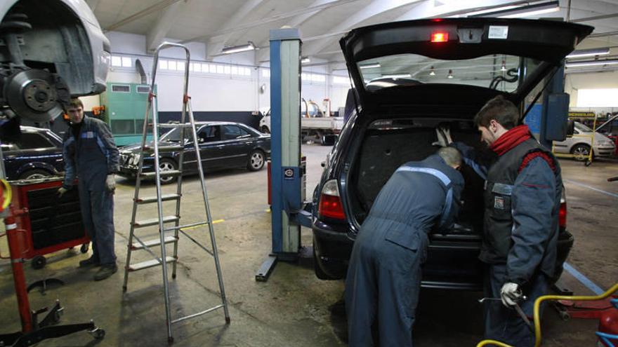 Mecánicos arreglando un coche en un taller de reparación.