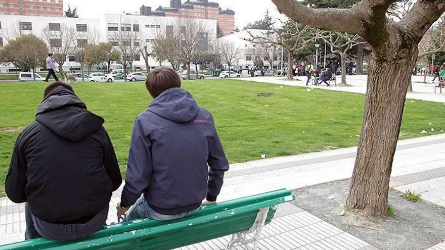 Dos jóvenes, sentados en un banco en el exterior del Instituto de Educación Secundaria Navarro Villoslada de Pamplona.