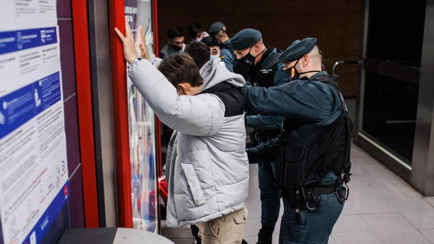Agentes de la Guardia Civil cachean a jóvenes en un control para prevenir la violencia entre bandas juveniles.