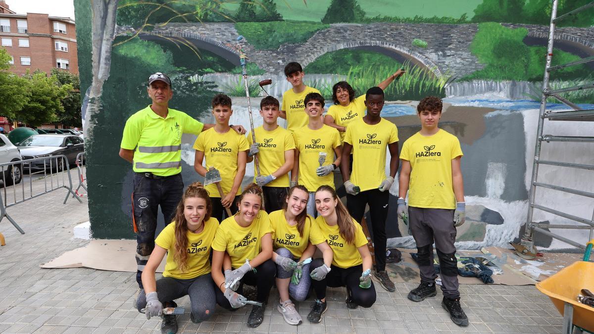 Integrantes del grupo Haziera, posan frente al mural junto con jefe de obras del Ayuntamiento de Villava, Iban Iturri, y la muralista Bea Millán.