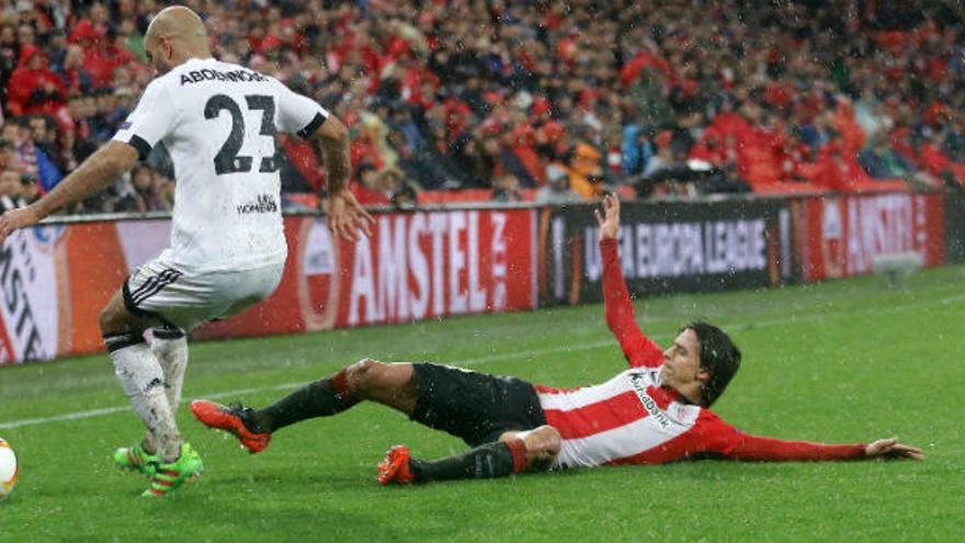 Ander Iturraspe se lanza al suelo para intentar interceptar el balón ante la oposición del valencianista Abdennour.