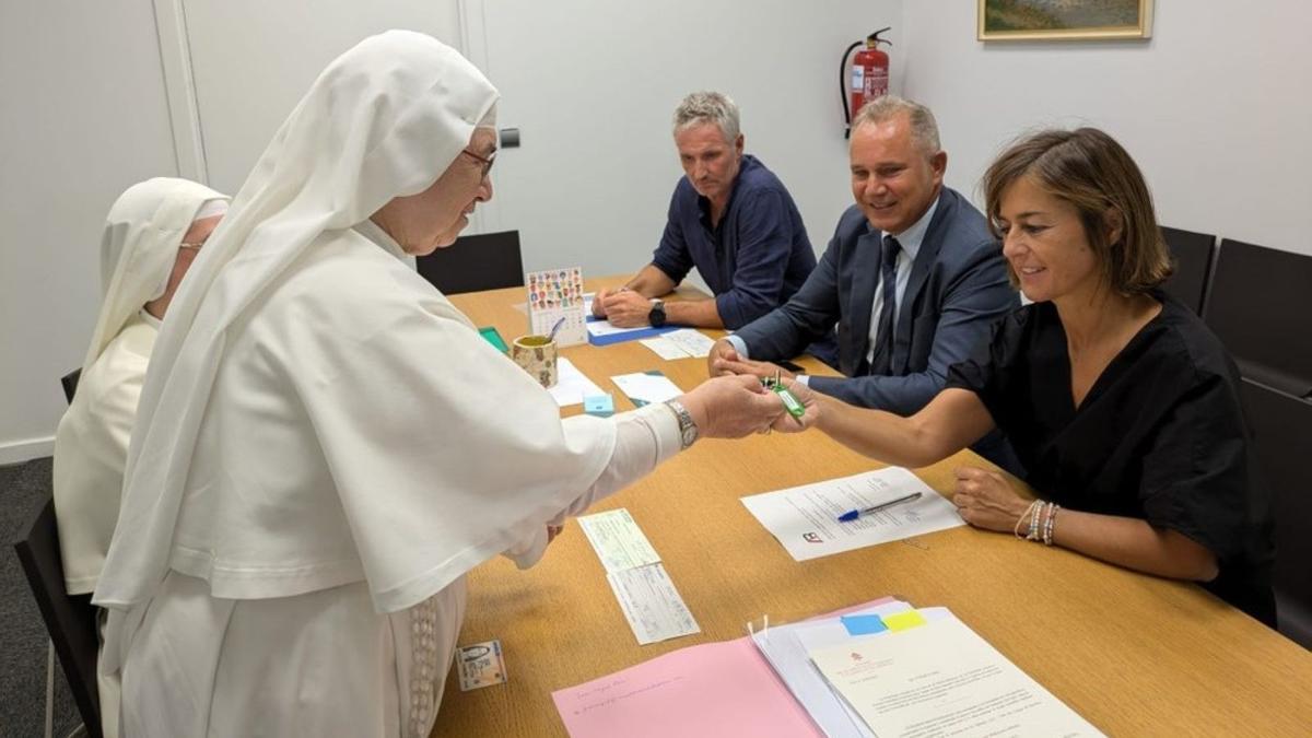 Nagore Alkorta, recogiendo las llaves de manos de representantes de la congregación tras la materializacion de la compra.