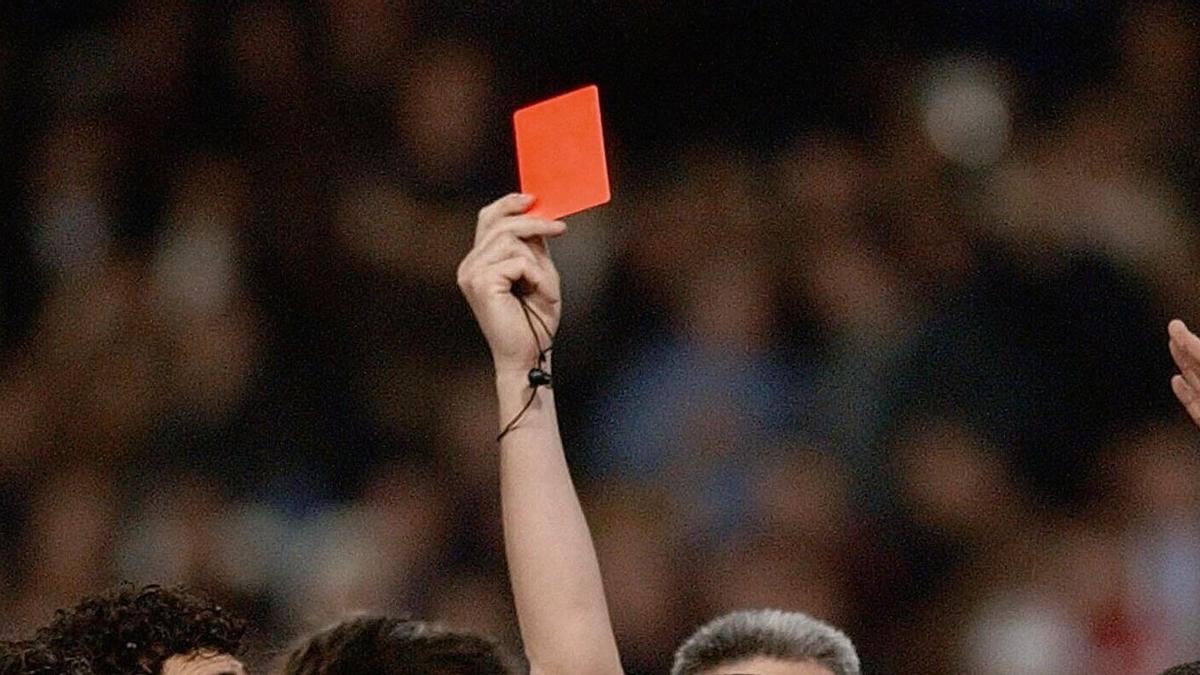 Un árbitro mostrando cartulina roja.