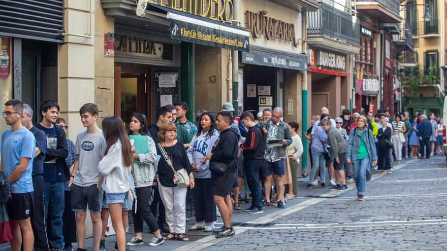Colas para recoger una de las 400 banderolas con el escudo de Pamplona