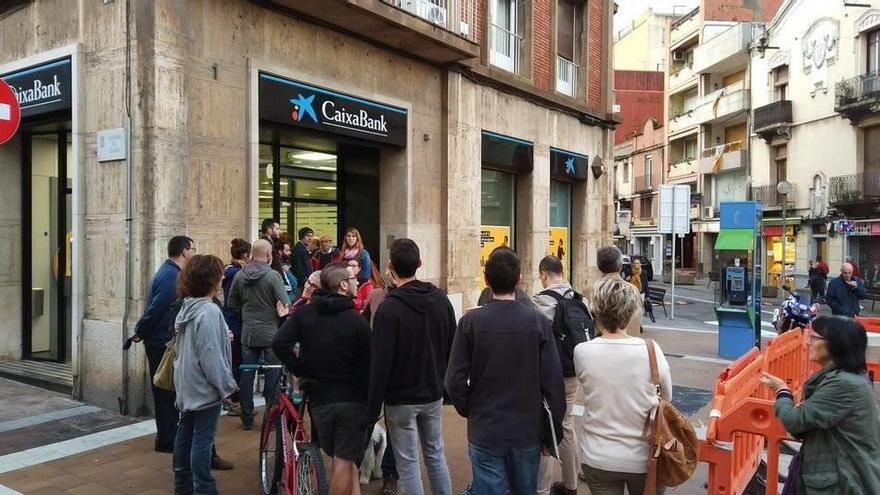 Una cola de personas a las puertas de una entidad bancaria. El hastag #LaForçaDeLaGent se ha convertido en trending topic mundial en Twitter.
