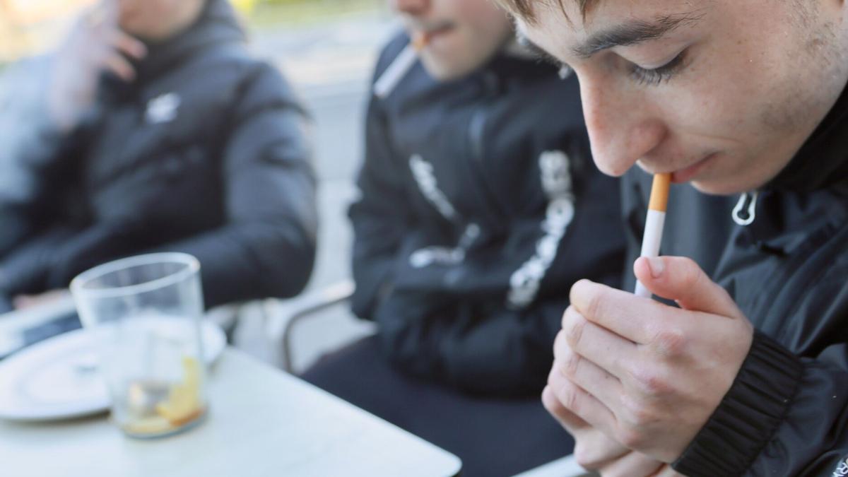 Jóvenes fumando tabaco en una terraza.