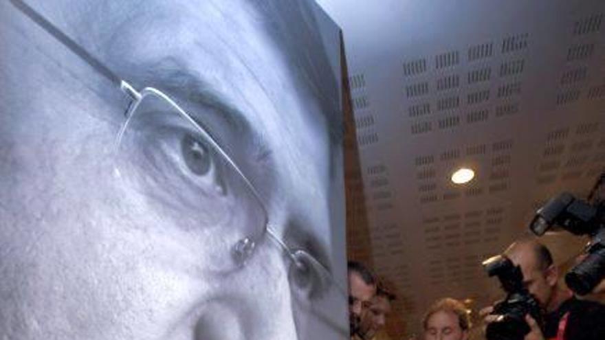 Patxi López firma sobre un póster suyo antes de la comparecencia