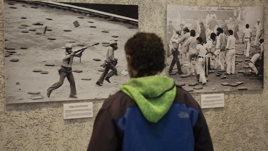 Visitantes viendo las fotografías de la muestra organizada por la iniciativa Sanfermines 78: Gogoan! sobre los sucesos de San Fermín de 1978 en los que murió Germán Rodríguez, con motivo del 40 aniversario de los hechos.