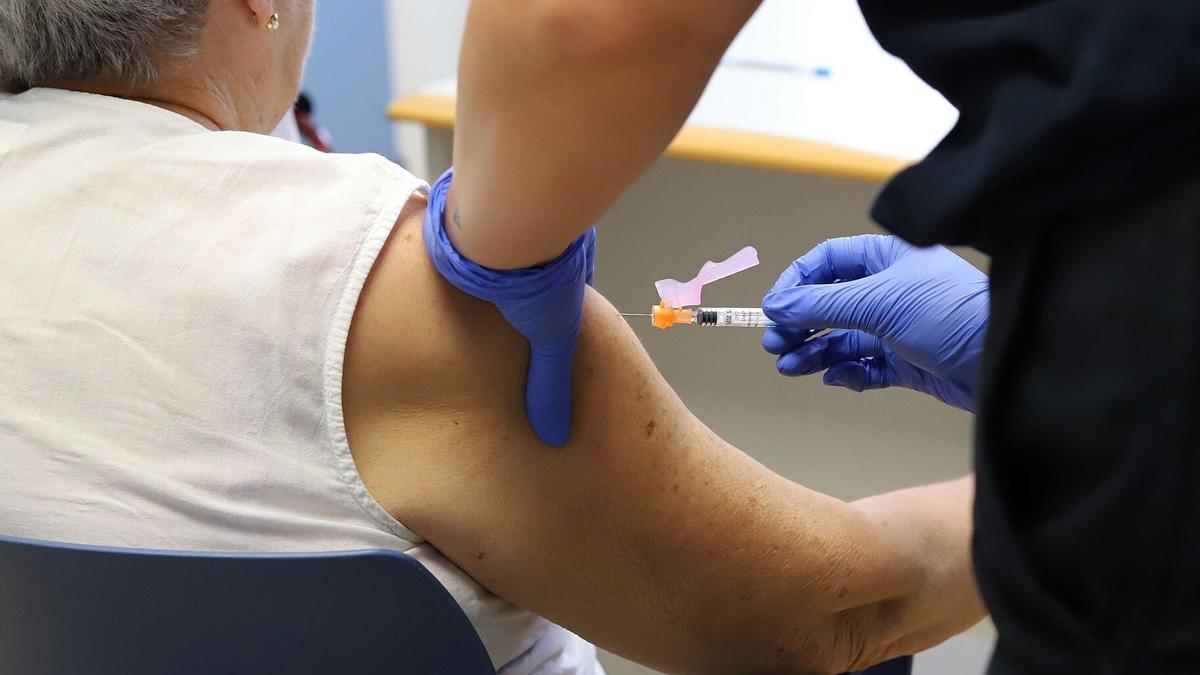 Una enfermera inocula una vacuna a un paciente en el inicio de la campaña de la vacunación contra la gripe estacional y la covid.