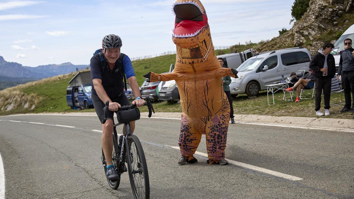 Aner Zilbeti, disfrazado de dinosaurio, anima a un ciclista.