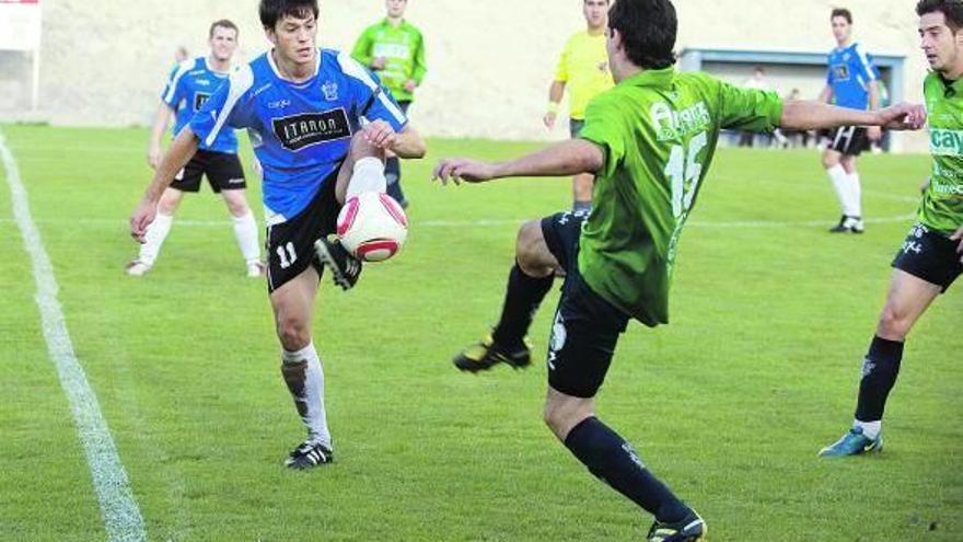 Un balón dividido es luchado por los jugadores del Itaroa Huarte y del Iruña.