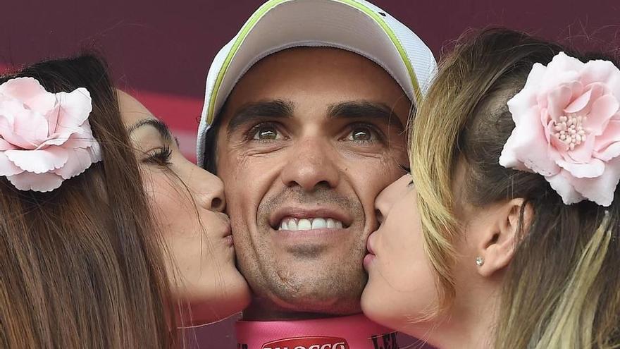 El ciclista español del Tinkoff-Saxo Alberto Contador es felicitado por dos azafatas en el podio.