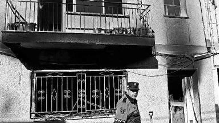 Un policía pasa por delante del edificio calcinado.