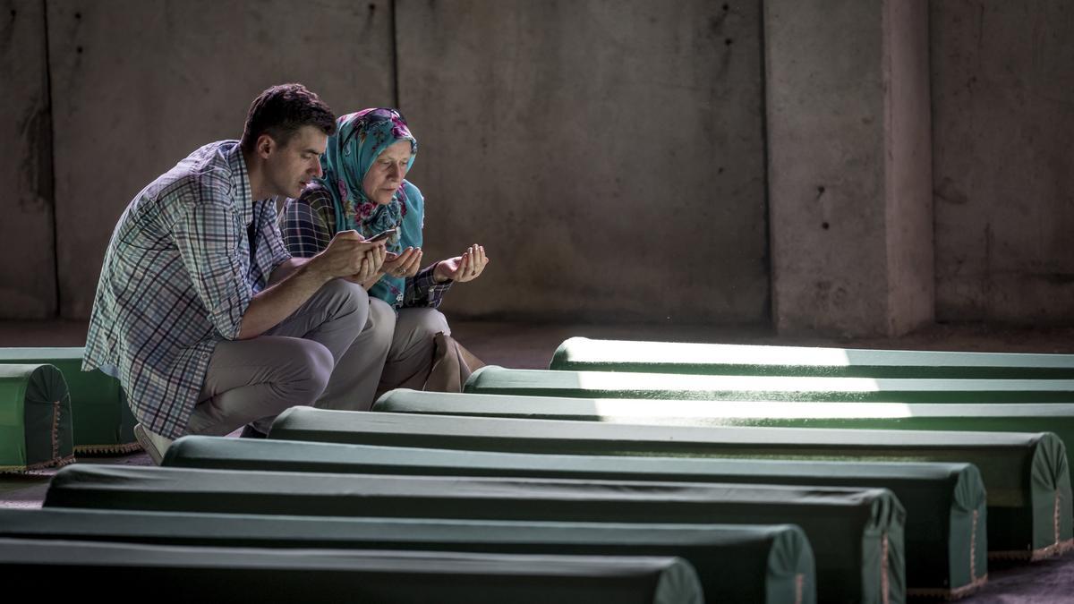 Dos familiares lloran junto a un ataúd, en el cementerio del centro conmemorativo de Potocari, coincidiendo con el XXII aniversario de la matanza de musulmanes a manos de las tropas serbobosnias en 1995 en el enclave bosnio de Srebrenica, que le costó la vida a más de 8.000 civiles musulmanes.
