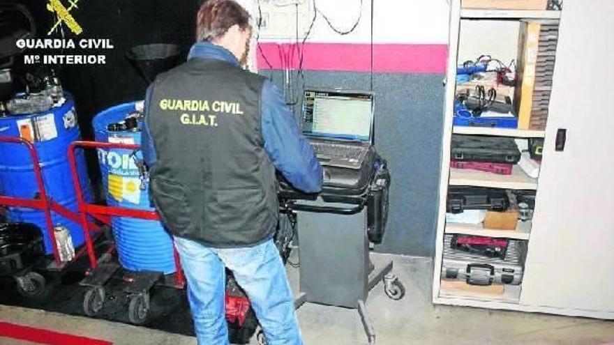 Un agente del Grupo de Investigación y Análisis de Tráfico (GIAT) de la Guardia Civil, durante el registro del negocio de compraventa.