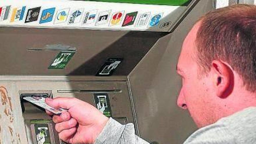 Un hombre introduce una tarjeta en un cajero automático.