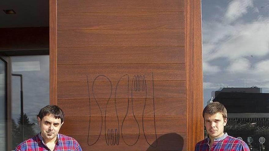 Iker Isiegas, camarero, y Javier Zarranz, propietario, posan en la puerta del Akari Gastroteka, el primer establecimiento del barrio de Lezkairu.