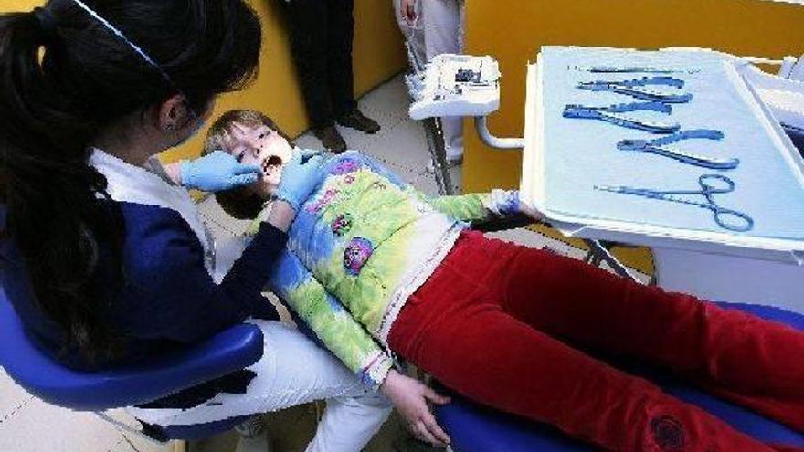 Una dentista revisa la boca de un niño.