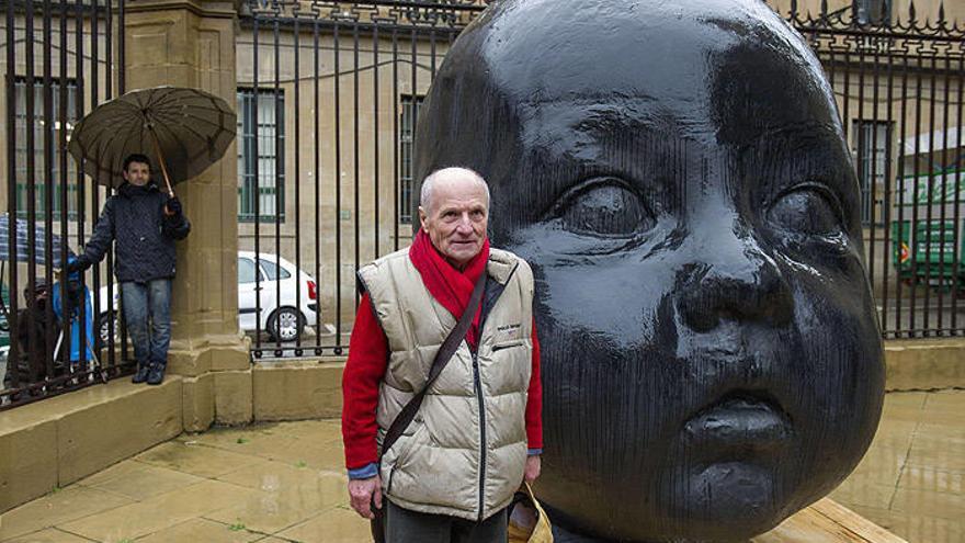 El escultor Antonio López, junto a una de las dos grandes cabezas de fundición de bronce que se han situado delante de la fachada neoclásica de la catedral de Pamplona.