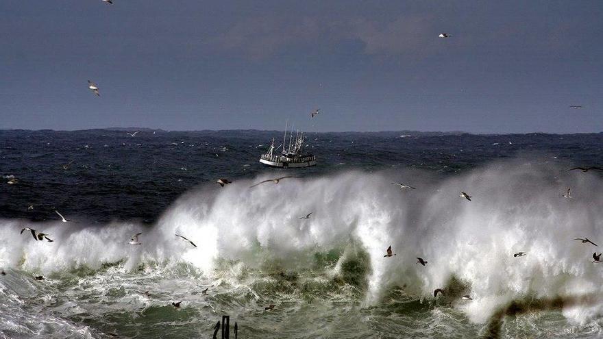 Un barco sale a faenar por las inmadiaciones de la Torre de Hércules, en A Coruña.
