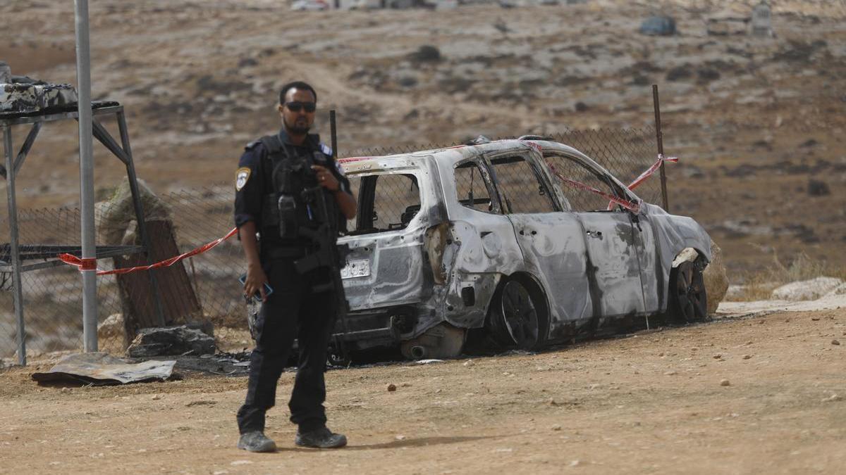 Un policía de Israel junto a un vehículo atacado por colonos israelíes en Masafer Yatta.