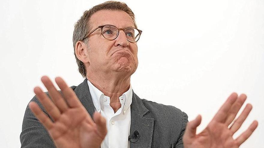 El presidente del PP, Alberto Núñez Feijóo, responde con gesto circunspecto y expresivo.