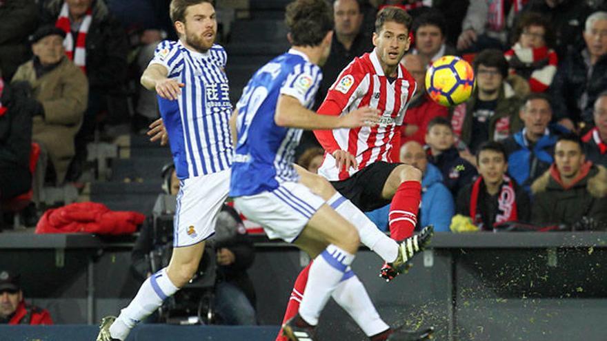 Enric Saborit centra un balón en el derbi frente la Real y ante la oposición de Illarramendi y Odriozola.
