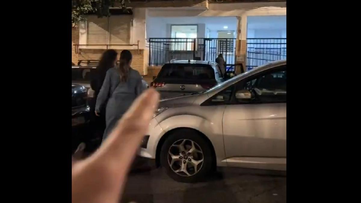 Un fragmento del vídeo, con el coche de las jóvenes bloqueado por la doble fila.