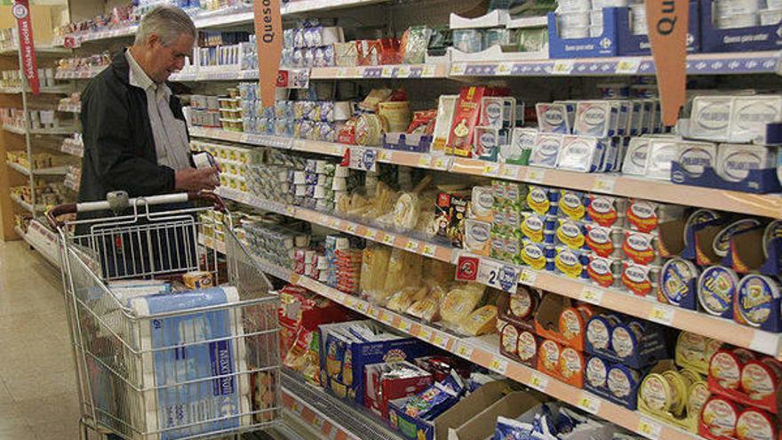 Un hombre, comparando productos en un supermercado.