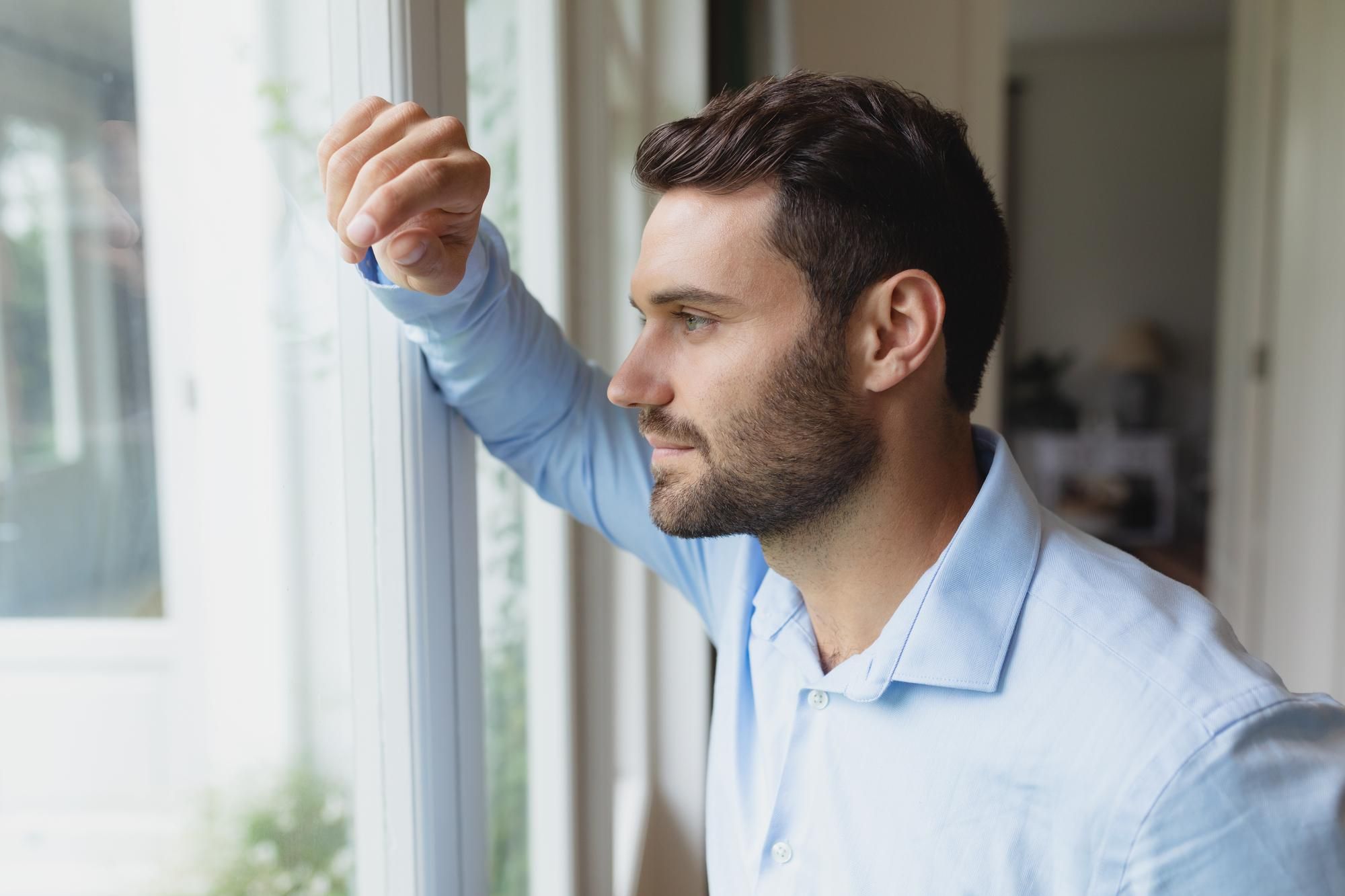 Un hombre se relaja mirando por la ventana.