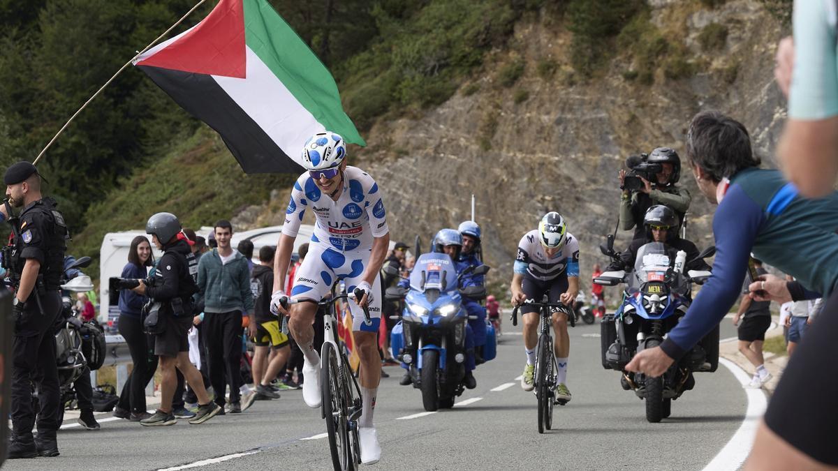 Vine, ganador de la etapa, pasa por debajo de una bandera de Palestina en la subida a Belagua.