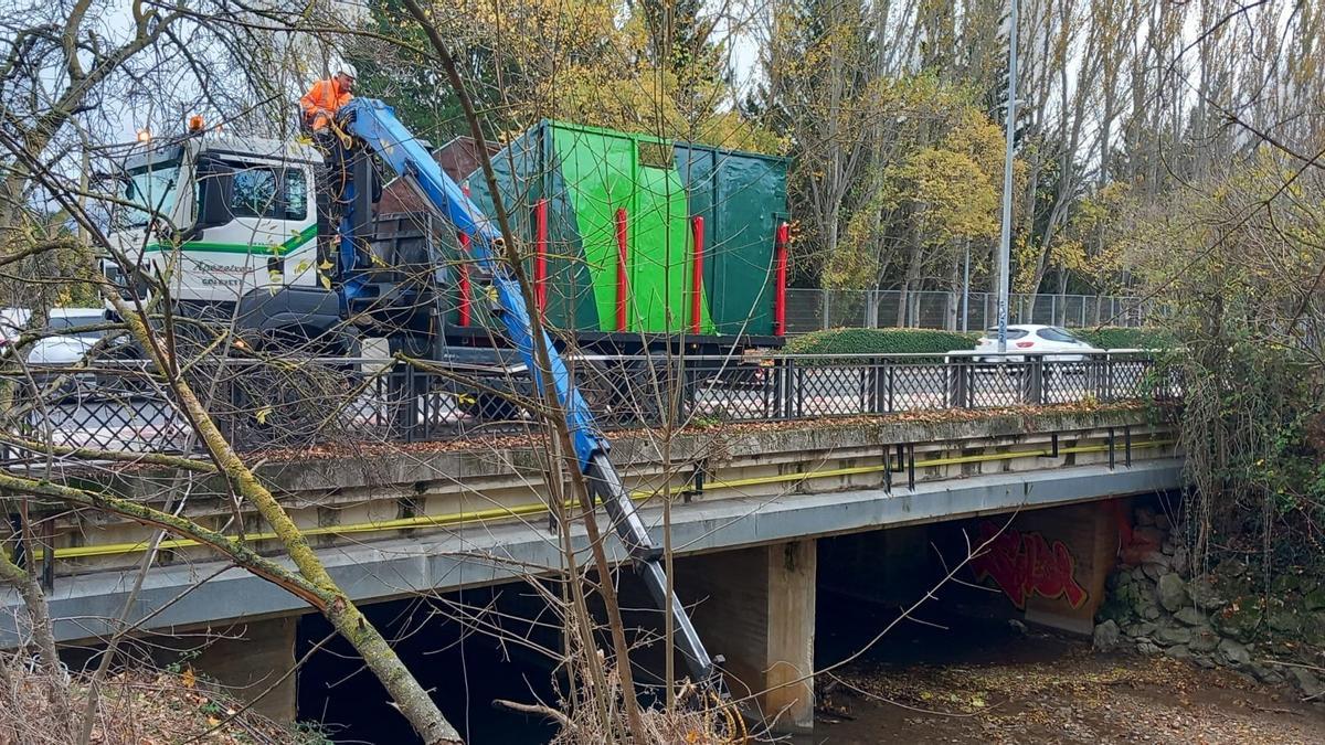 Un vehículo, retirando residuos del río.