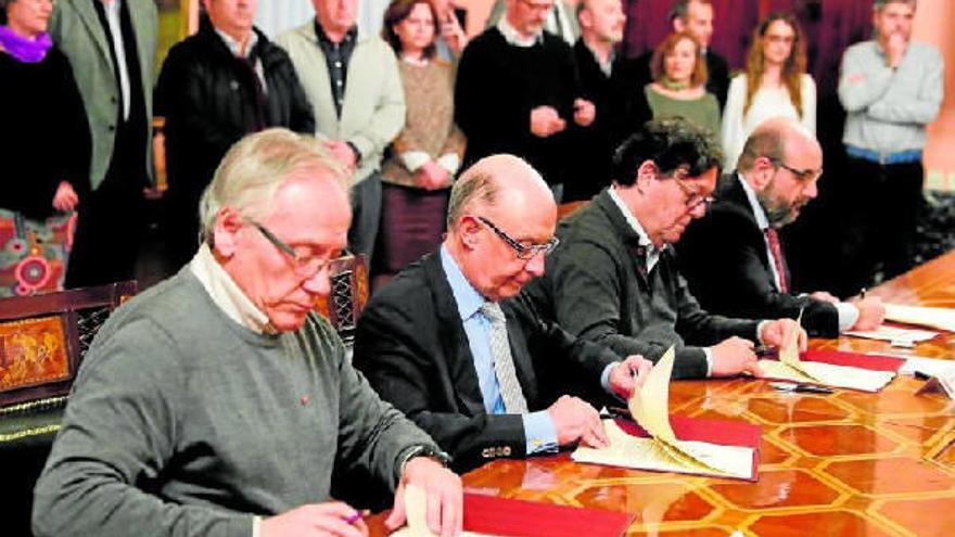 El ministro de Hacienda y Función Pública, Cristóbal Montoro, firma el acuerdo con CCOO, UGT y CSIF.