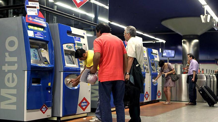 Usuarios del Metro de Madrid frente a las máquinas dispensadoras.