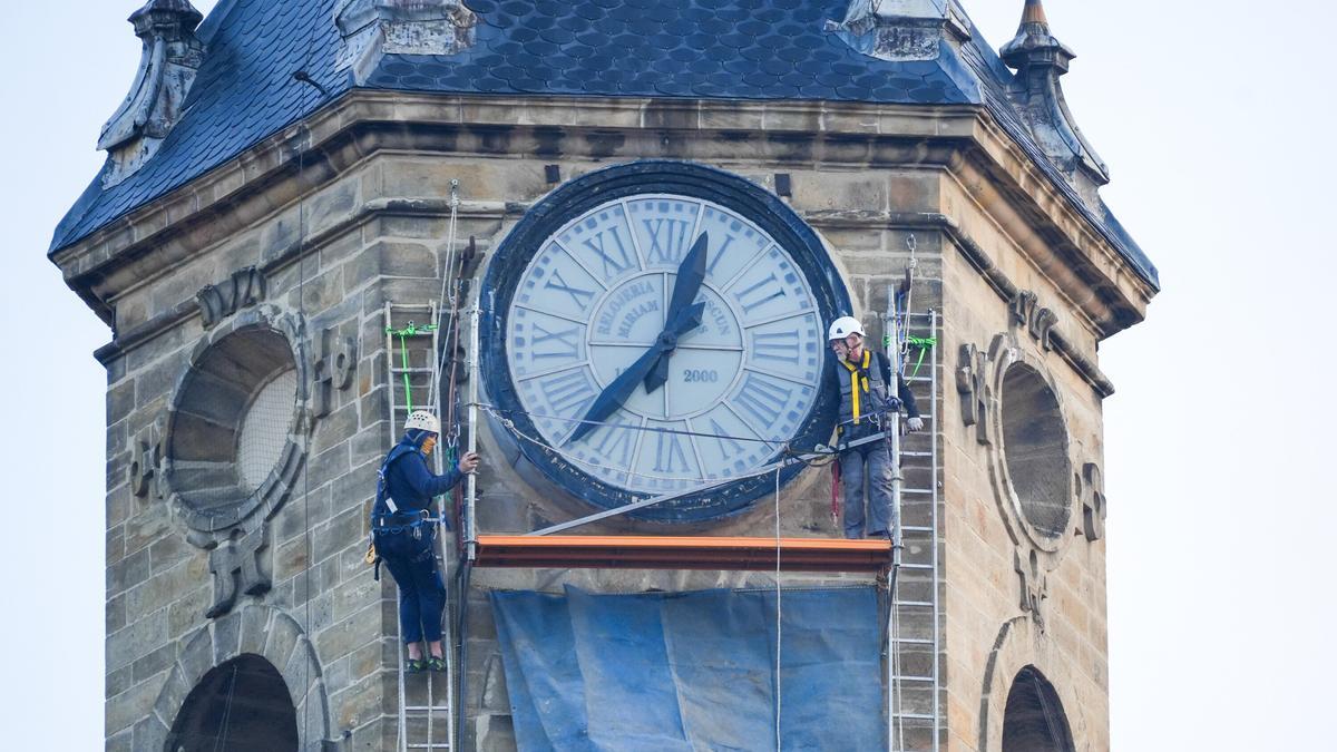 Operarios trabajan en el reloj de la iglesia San Miguel