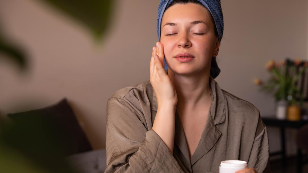 Una mujer después de exfoliar e hidratarse el rostro