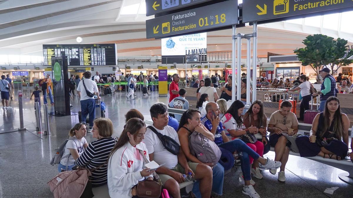 Varias personas esperan en la zona de Salidas del aeropuerto de Bilbao.