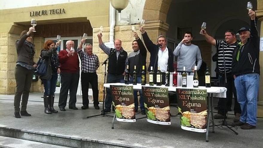 La alcaldesa de Lezama, Alaitz Etxeandia, alza su copa junto a los productores de la zona, mientras estos entonan una cancioón en el brindis de la feria
