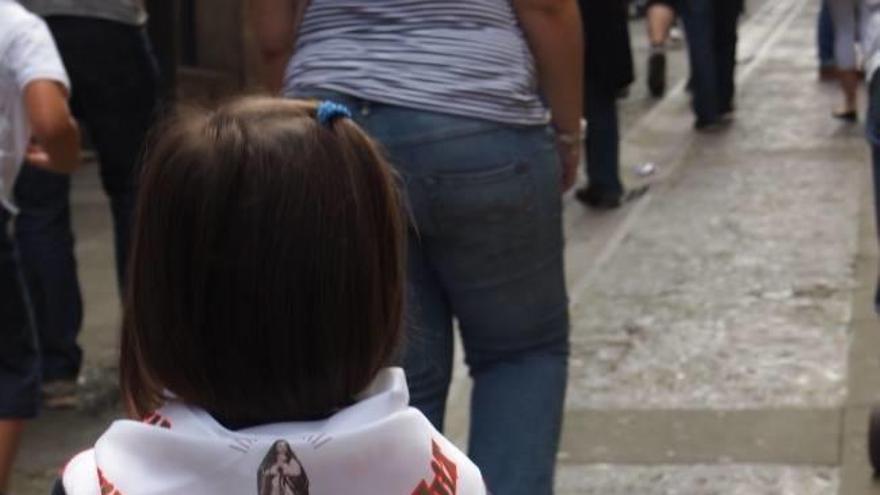 Una niña pasea el pañuelo de la fiesta.