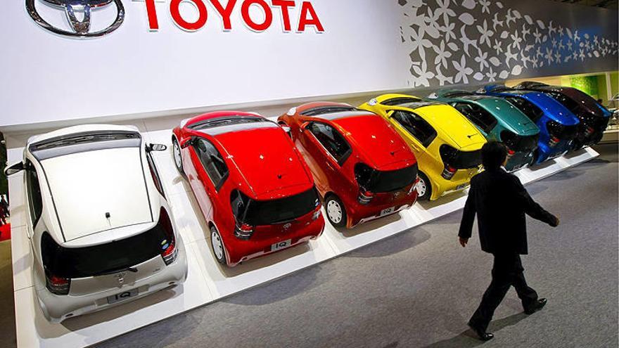 Un hombre pasando por delante de una hilera de IQs, de Toyota Motor, durante la inauguración de la 41 edición del Salón del Automóvil de Tokio.