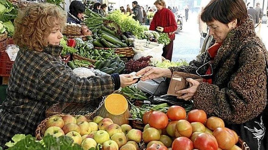 Una mujer compra en un puesto de la Bretxa.