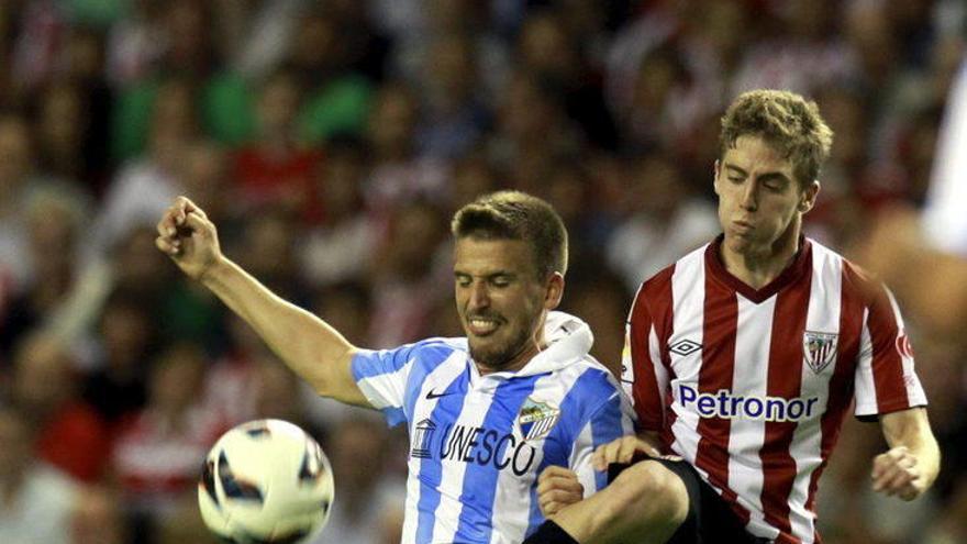 Iker Muniain disputa un balón con Nacho Monreal.
