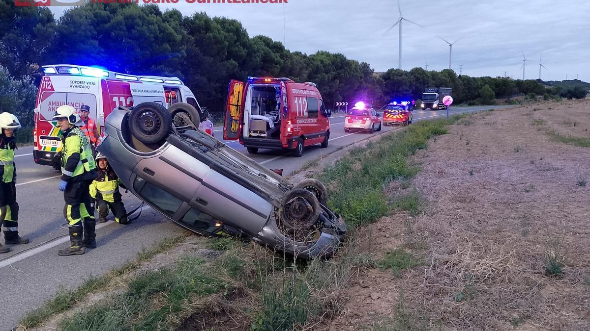 El coche, volcado sobre la cuneta.