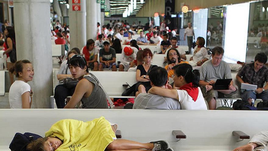 Jóvenes esperan el autobús tras una noche de fiesta.