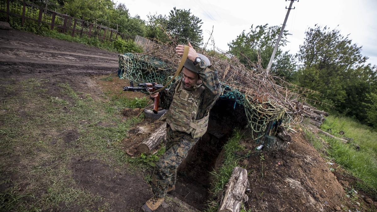 Un soldado ucraniano sale de una trinchera en un bosque del país.