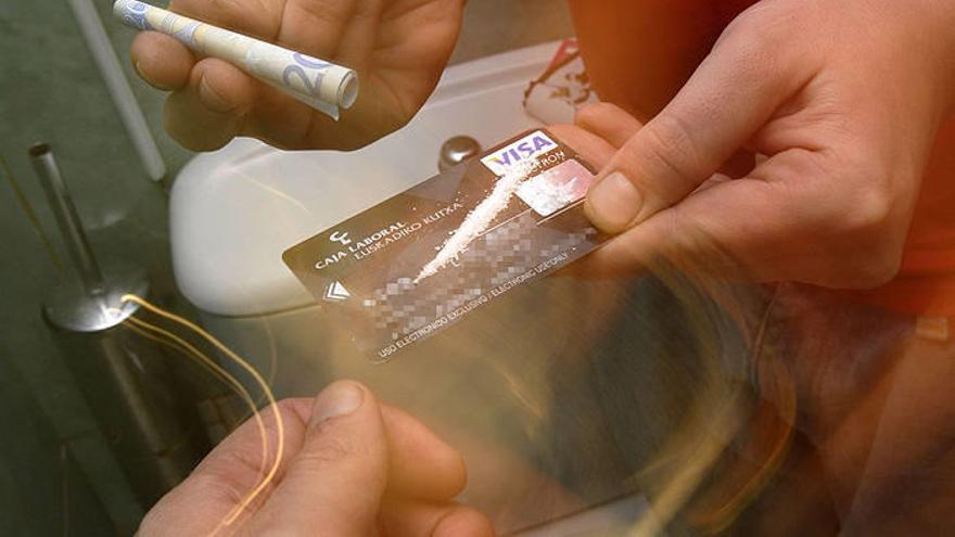 Joven a punto de consumir una raya de cocaína en el baño de un bar.