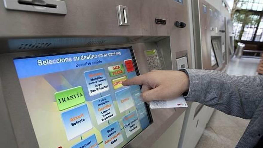 Un usuario dispuesto a pagar un viaje en una expendedora de Euskotren en la estación de Atxuri.