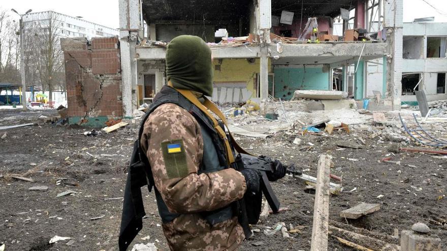 Un soldado ucraniano, frente a edificios destruidos.